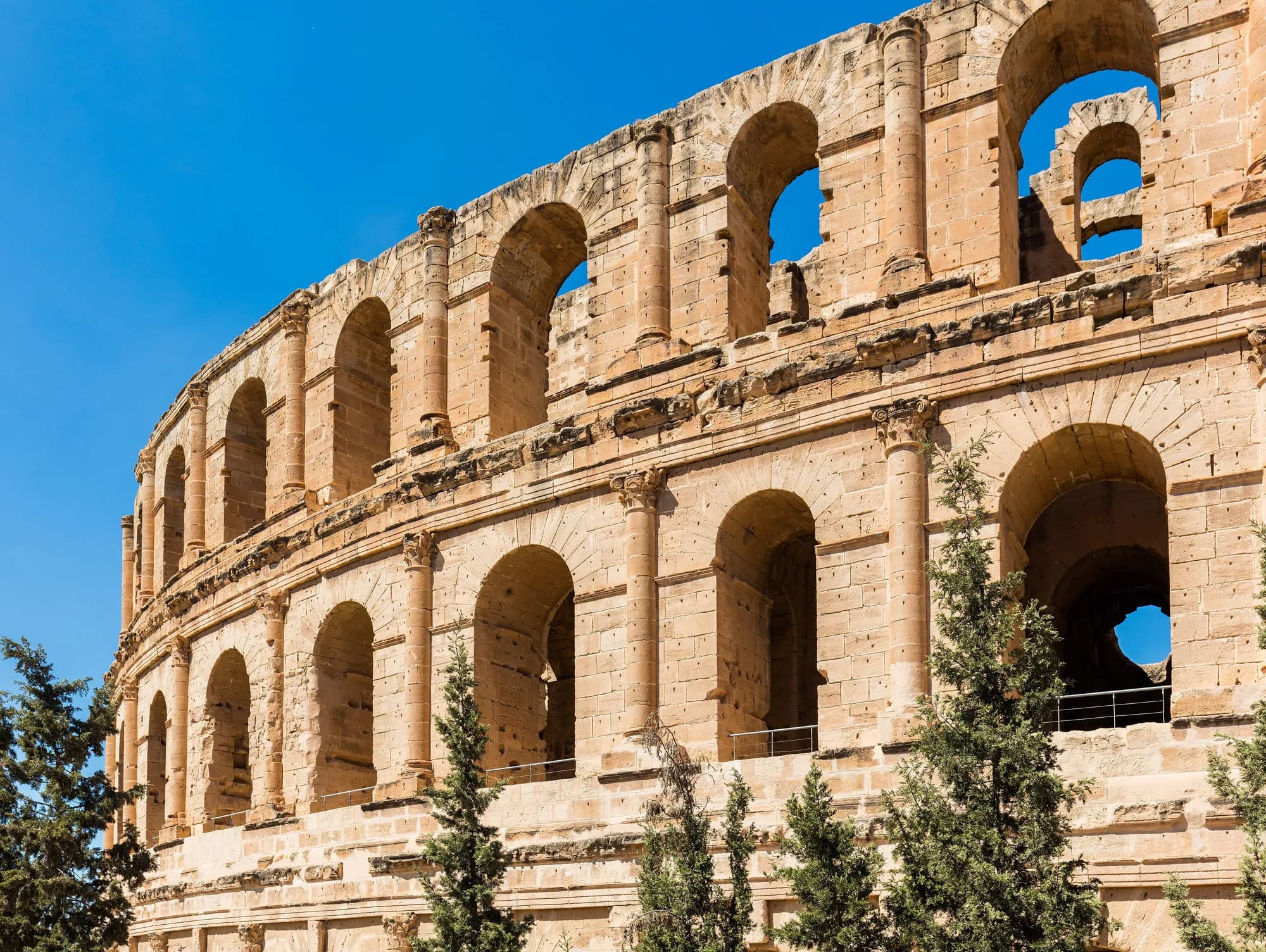 Arches of the El Jem amphitheatre against a blue sky